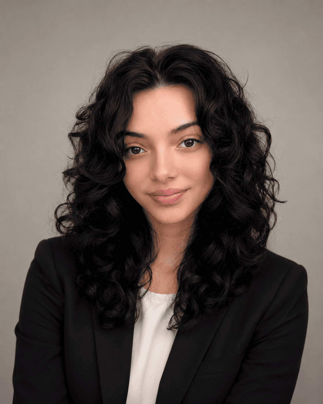 Smiling woman with curly hair and blazer.